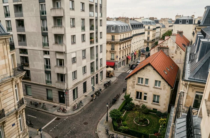 Vue urbaine comparant un immeuble d'appartements moderne et une maison individuelle dans un quartier français